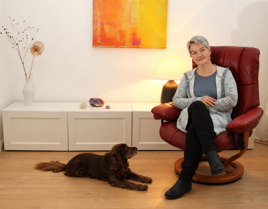 Dr.Erle sitzt mit Hund im Behandlungsraum